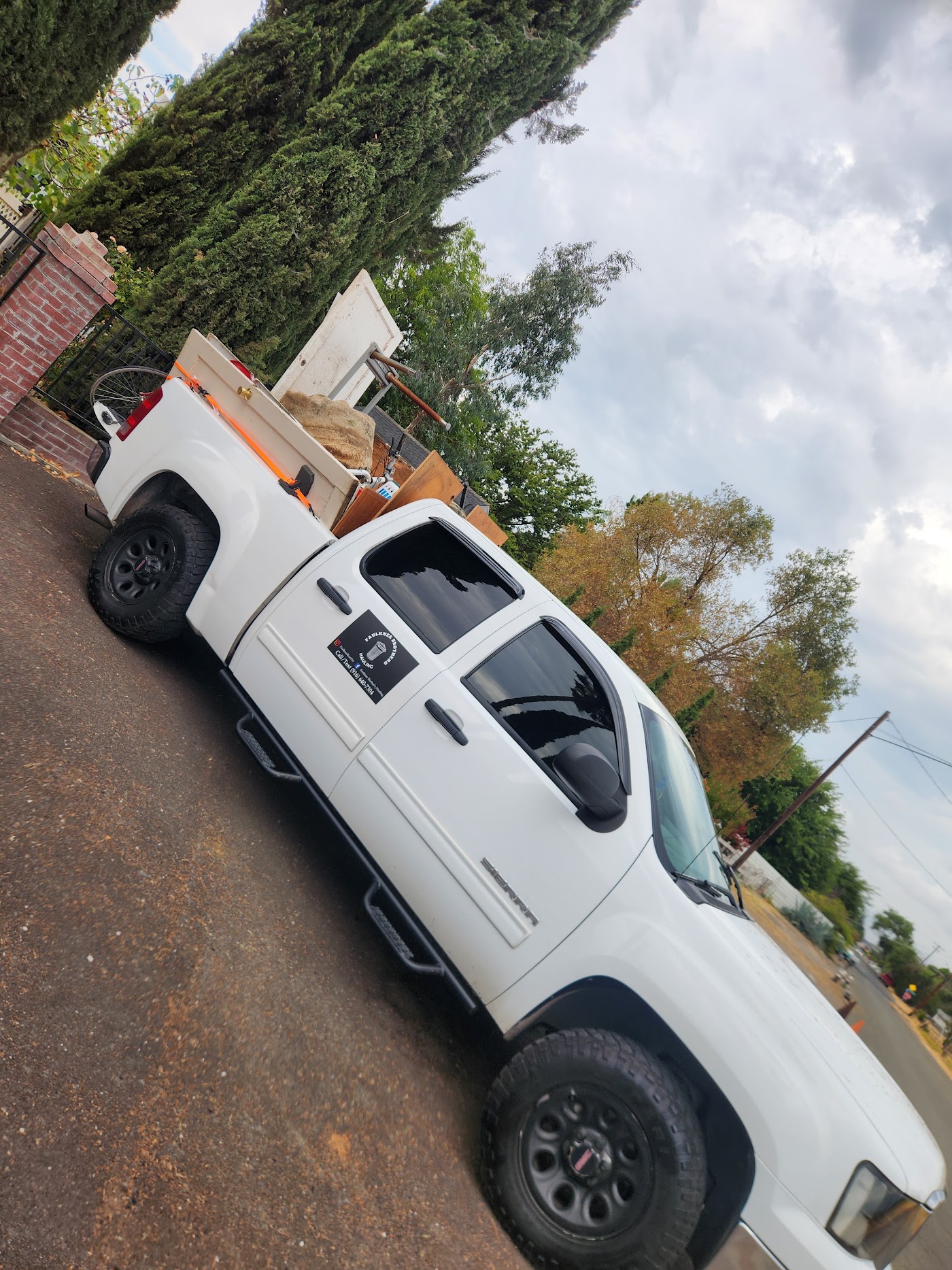 Truck loaded with plywood and building material beside a house