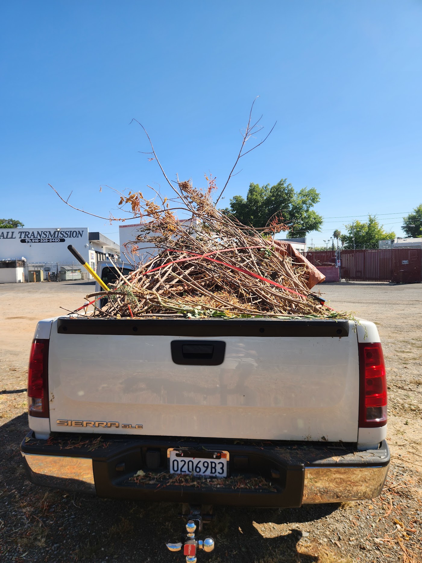 Truck bed loaded with tree branches and yard brush