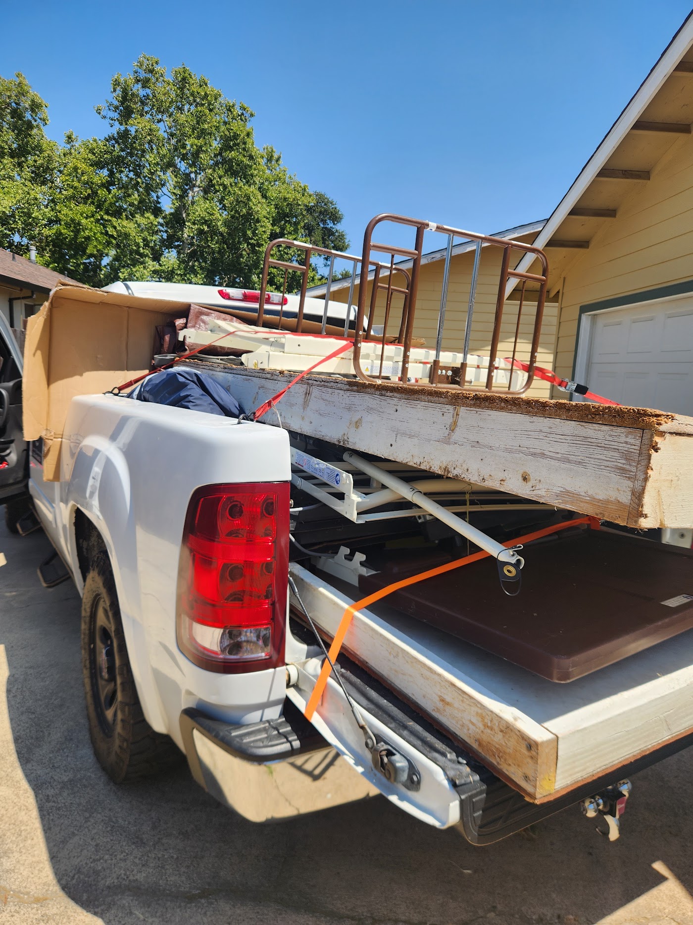 Truck bed carrying an old metal bed frame and mattress