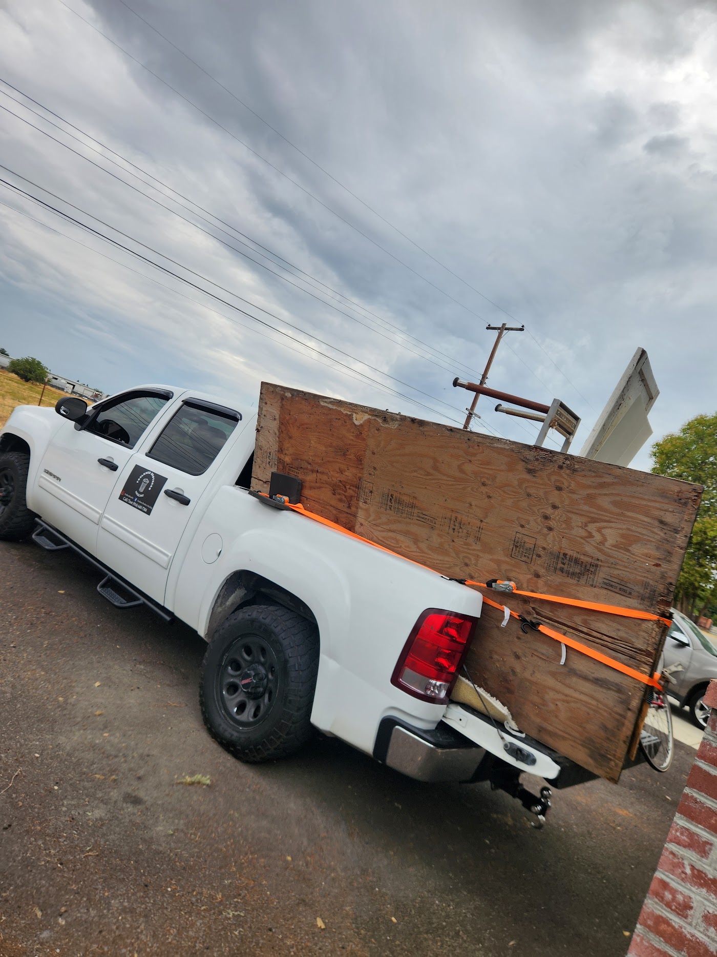 Pickup with plywood secured in the bed on a cloudy day